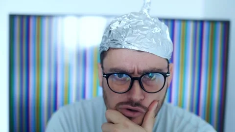 Man wears a tinfoil hat, expressing disbelief and paranoia about conspiracy Stock Footage 307823647