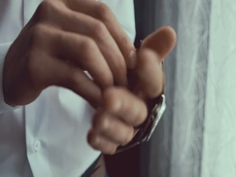 A man wears watch at the window Stock Footage 71827873