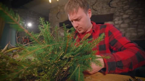 Man Weaves In Pine Needle Branch Into Rustic Wreath In Christmas Workshop Stock Footage 253120481
