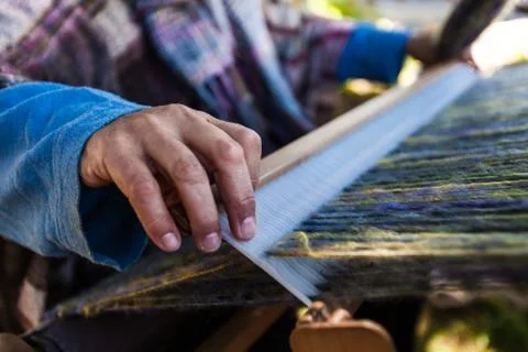 Man is weaving very fancy multi colored wool using a wooden loom - 4/6 Foto stock