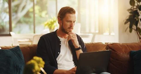 Man, website and reading on sofa with laptop, writer and thinking for script Stock Photos