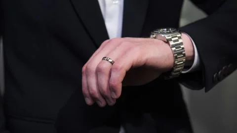 Man with wedding ring looking at wrist watch in jewerly store. Video stock 242775852