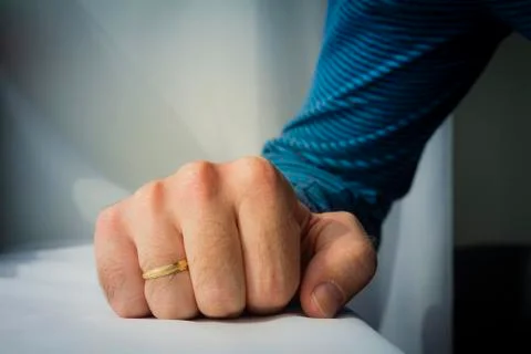 Man with a wedding ring squeezed his hand on white cloth background Stock Photos