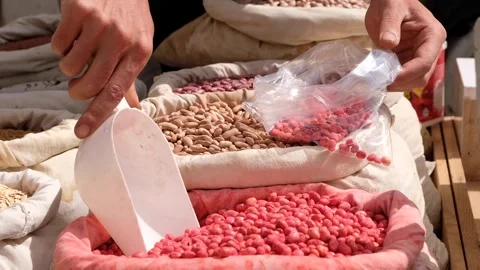 Man weighs beans with his hand in Turkish bazaar 2 Stock Footage 294166830