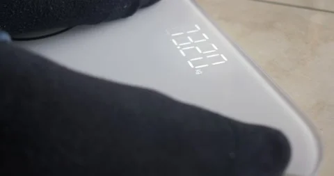 Man weighs himself on a digital scale. Selective focus on electronic display. Stock Footage 147723819