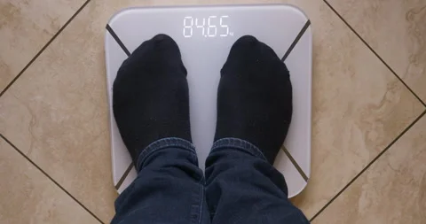 Man weighs himself on a digital scale. Top view. Stock Footage 147849632