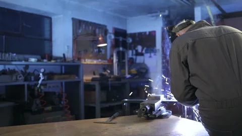 A man welding in his workshop and testing the metal after he is done. High defi Stock Footage 88356329