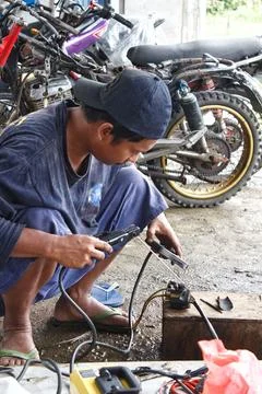 A man is welding a motorcycle switch Photos