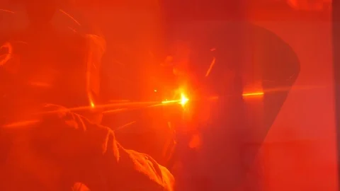 Man welding a pipe behind a red curtain in slow motion Stock Footage 120297933