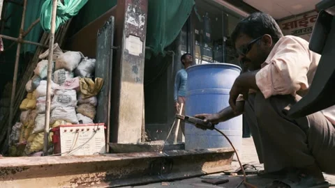 Man welding on the streets of mumbai - daily workers of india - Stock Footage