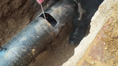 A man is welding a thick iron pipe. Stock Footage 323380638