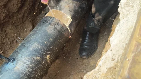 A man is welding a thick iron pipe. Stock Footage 323380644
