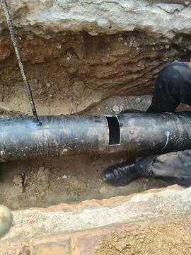 A man is welding a thick iron pipe. Stock Photos