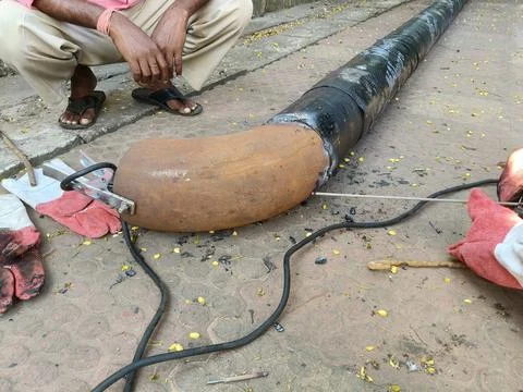 A man is welding a thick iron pipe. Stock Photos