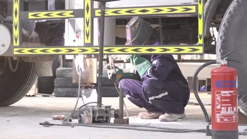 Man welding the underside of the car in desert project slow motion Stock Footage 144801053