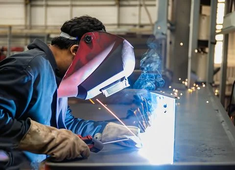 Man welds at the factory Stock Photos