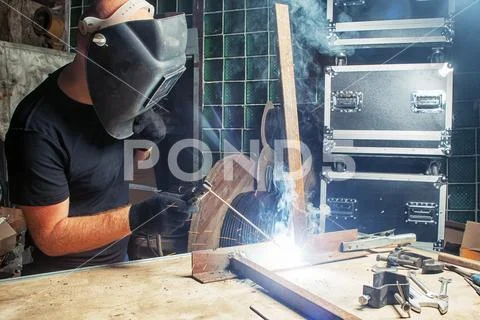 Man Welds A Metal Arc Welding Machine