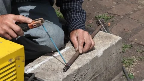 A Man welds a metal pipe Stock Footage 133646347