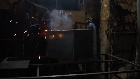 A man welds metal in a protective mask. Nice epic shot. Welding works. Stock Footage 257932432