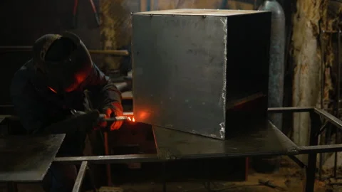 A man welds metal in a protective mask. Nice epic shot. Welding works. Stock Footage 257932472