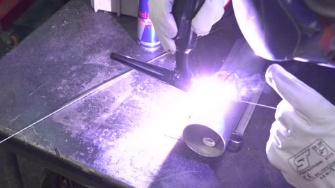 Man welds a pipe Stockbeeldmateriaal 135826353