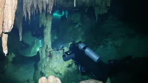 A man in a wet suit is diving in a cave Video stock 309986591