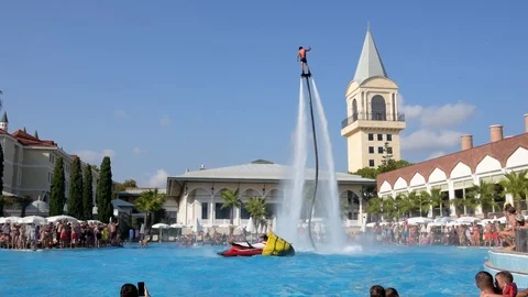 Man in wetsuit on flyboard fly in pool hotel on air jet or water pressure force Stock Footage 123306045
