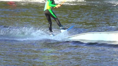 Man in in wetsuit rides on a wakeboard to the springboard, slow motion Stock Footage
