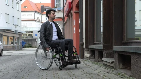 A man in a wheelchair cannot drive into a small shop Stock Footage 125512240