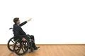 The man in a wheelchair gesturing on the white wall background Photo