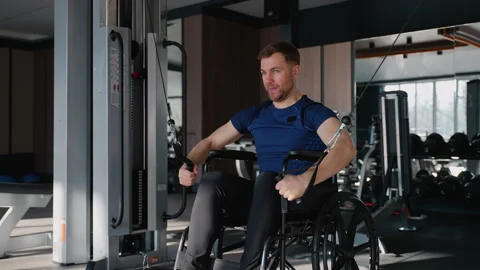 Man in wheelchair performing cable crossover exercise Video stock 309068261