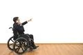 The man in a wheelchair phones and gestures on the white wall background Photo
