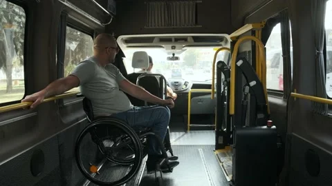 Man in wheelchair in the special the vehicle. The disabled person is transported Stock Footage 142741082