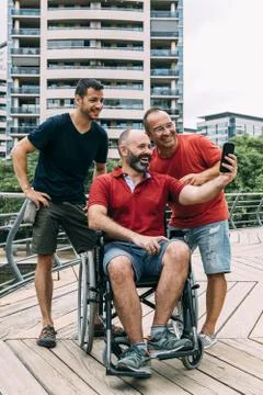 Man in wheelchair taking a selfie with two friends Stock Photos