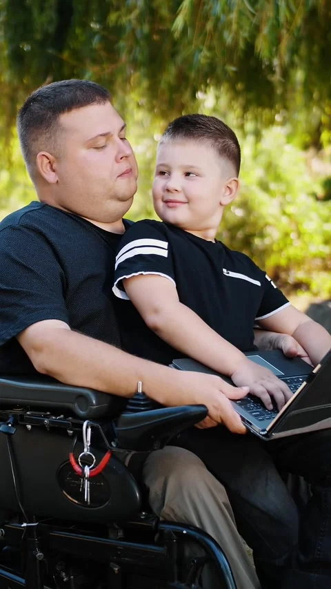 Man is a wheelchair user. dad and son. father's day. a man with his little son, Stock Footage 318727655
