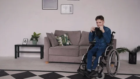 Man in wheelchair using virtual reality glasses at home Stock Footage 112426456