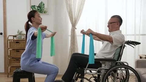 Man in wheelchair workout with nurse using band Video stock 196201336