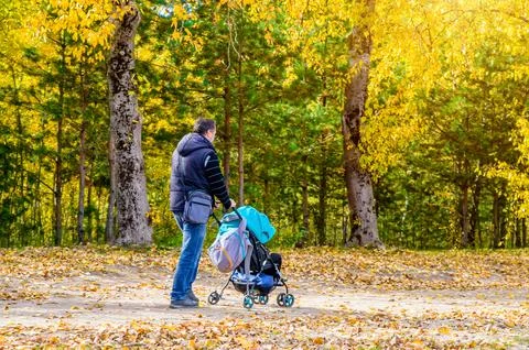Man wheeling a pram in the Park 写真素材