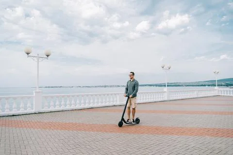 Man while riding on the electric scooter. Stock Photos