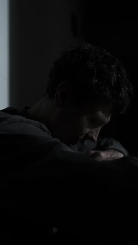 Man whispering to himself in the dark, stressed and overwhelmed, self-talk and Vídeo Stock 320786198