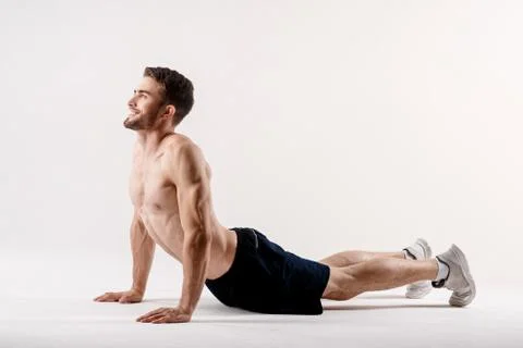 A man on a white background does an exercise on stretching his back. straight Stock Photos