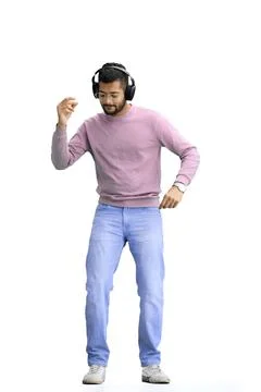A man, on a white background, in full height, listening to music with headphones Stock Photos