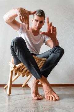 A man on a white background looks at the camera. men's photo shoot Stock Photos