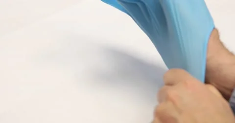 A man on a white background is wearing rubber medical gloves. Stock Footage 196191198