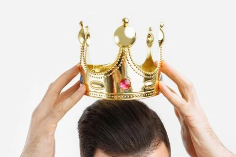 Man on a white background wears a crown on his head, in a photo Studio Stock Photos