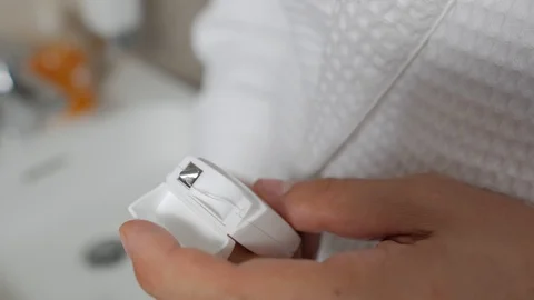 A man in a white Bathrobe opens a box of dental floss and takes it out. Oral 스톡 동영상 116501134