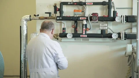 A man in a white coat fixes the temperature. Laboratory work. Stock-Footage 79643842