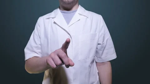 A man in a white coat stands in front of the screen and gestures. Video is perfe Stock Footage 113960756