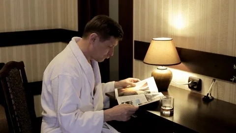 A man in a white coat at the table considering Journal Stock Footage 111685202