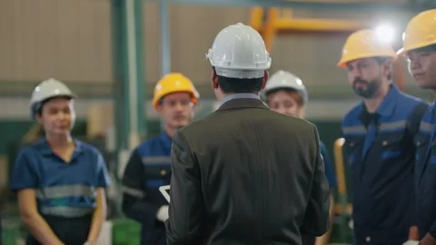 Man in white hard hat addresses group Stock Footage 341925313